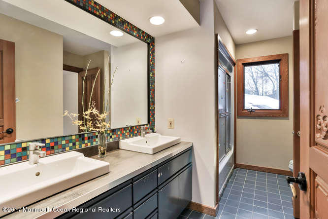 1644 Martin Road Neptune, NJ 07753 - Photo 28 of 42 a bathroom with a double vanity sink a mirror and a bathtub