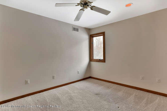 1644 Martin Road Neptune, NJ 07753 - Photo 30 of 42 an empty room with a ceiling fan and carpet