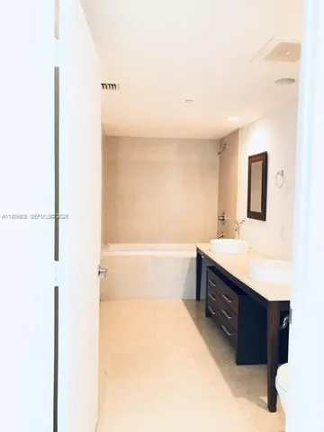 a bathroom with a tub sink and mirror