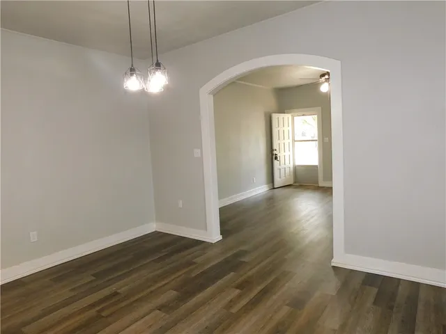 a view of a room with wooden floor and chandelier