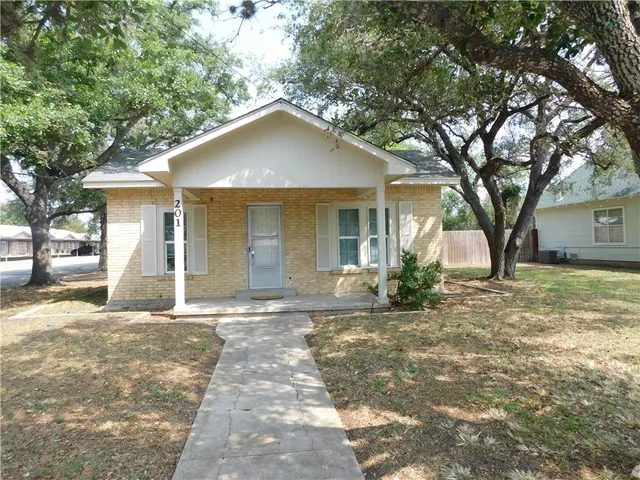 a house that has a tree in front of it