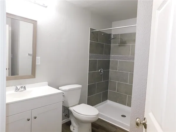 a bathroom with a sink a toilet and shower