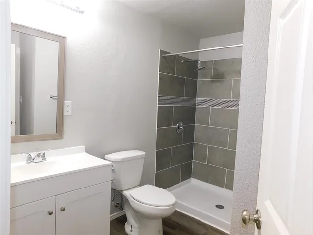 a bathroom with a sink a toilet and shower