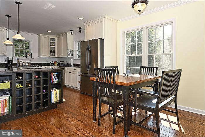 4904 South Chesterfield Road Arlington, VA 22206 - Photo 11 of 30 a view of a kitchen with stainless steel appliances granite countertop a stove a refrigerator a dining table and chairs with wooden floor