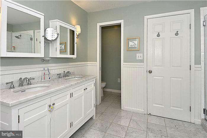 4904 South Chesterfield Road Arlington, VA 22206 - Photo 24 of 30 a bathroom with a granite countertop sink a toilet and a mirror