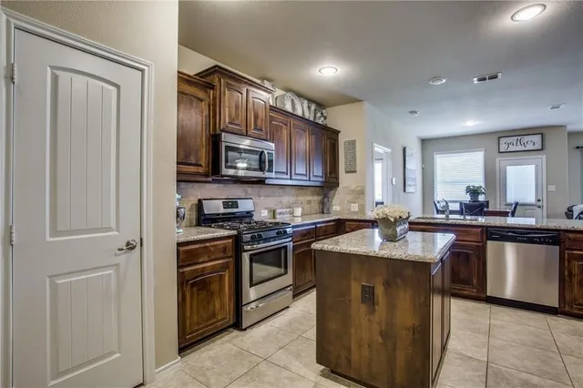 a kitchen with stainless steel appliances granite countertop a stove top oven a sink and dishwasher