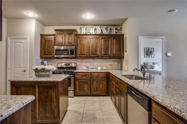 a kitchen with stainless steel appliances granite countertop a sink stove and cabinets