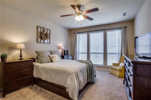 a bedroom with a bed and a flat tv screen on the dresser