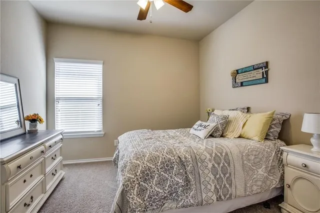 a bedroom with a bed and a flat tv screen on the dresser