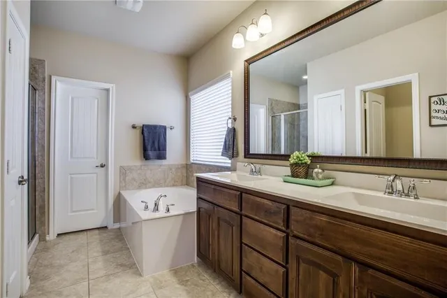 a bathroom with a granite countertop sink mirror and bathtub