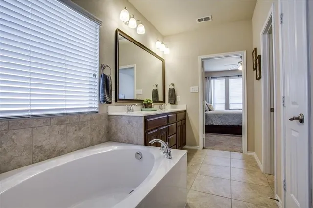 a bathroom with a tub a sink and a mirror
