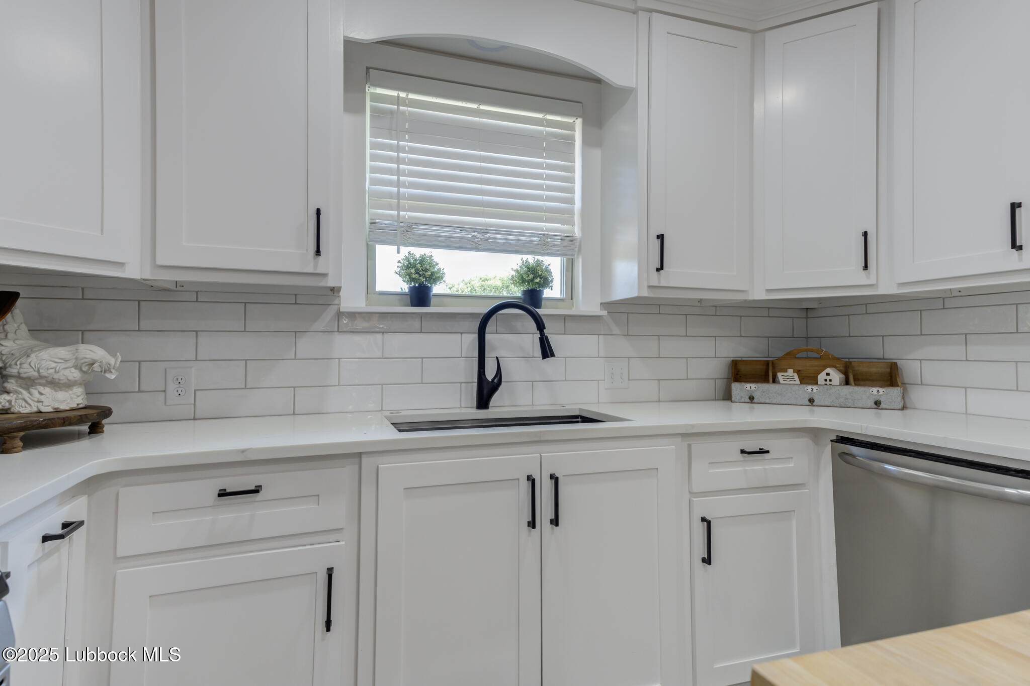 1205 Garland Plainview, TX 79072 - Photo 23 of 50 a kitchen with white cabinets and a window