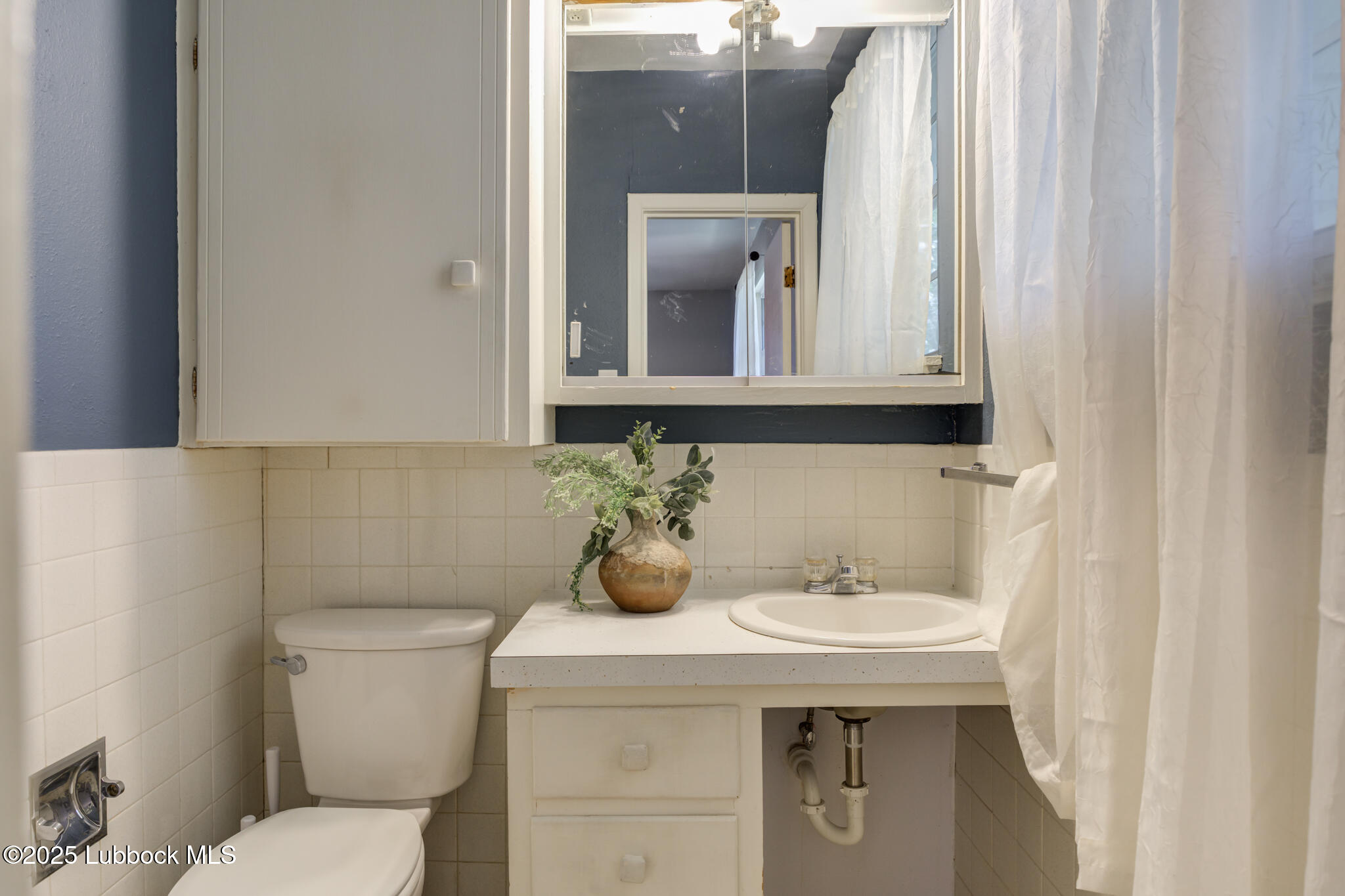 1205 Garland Plainview, TX 79072 - Photo 27 of 50 a bathroom with a sink a toilet and mirror