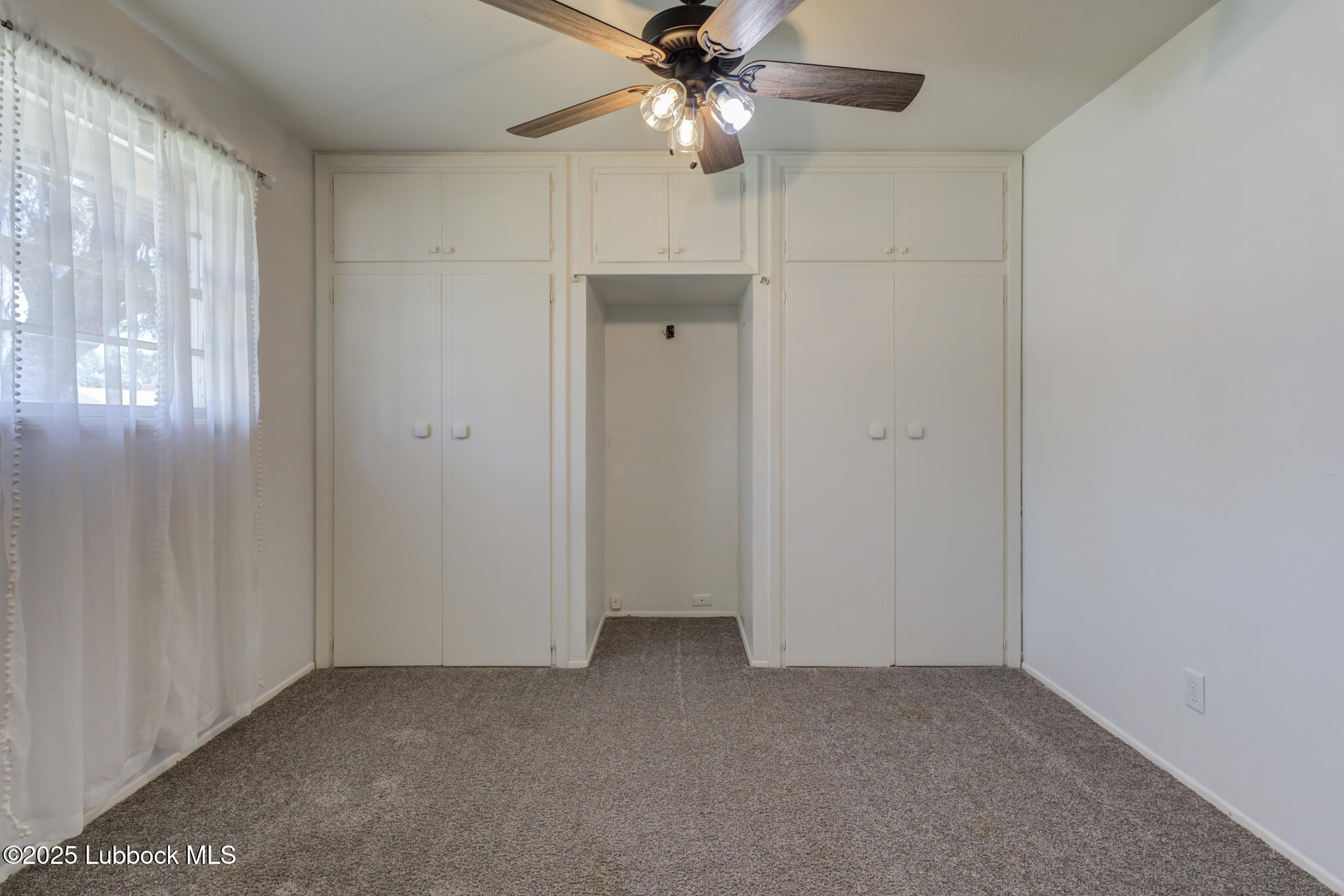 1205 Garland Plainview, TX 79072 - Photo 30 of 50 an empty room with windows and fan