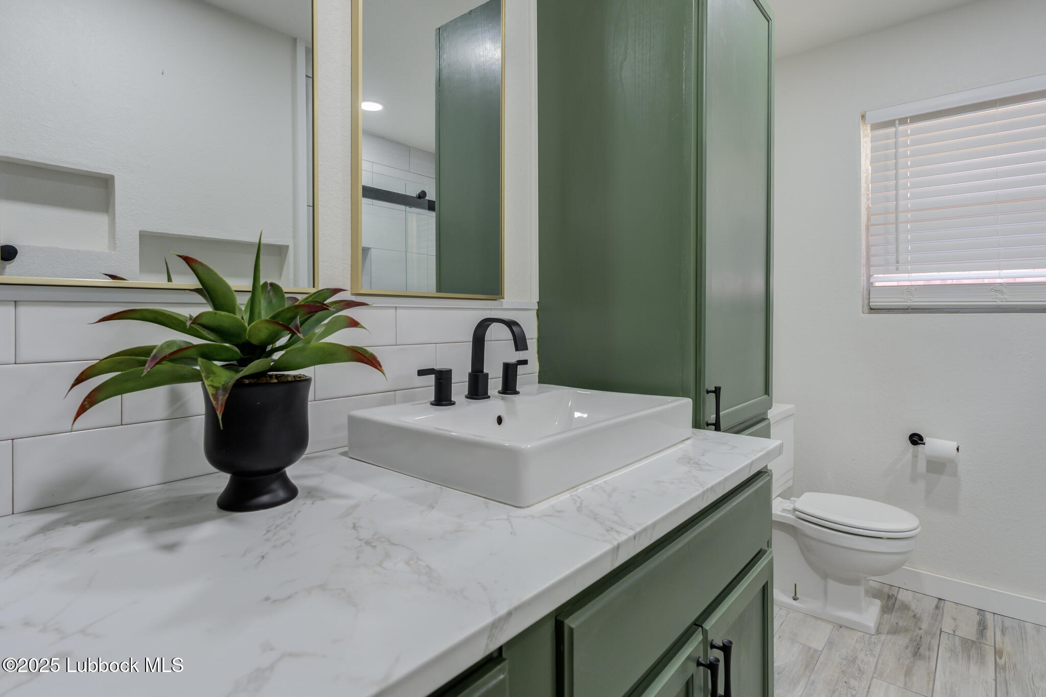 1205 Garland Plainview, TX 79072 - Photo 32 of 50 a bathroom with a sink a toilet and a mirror