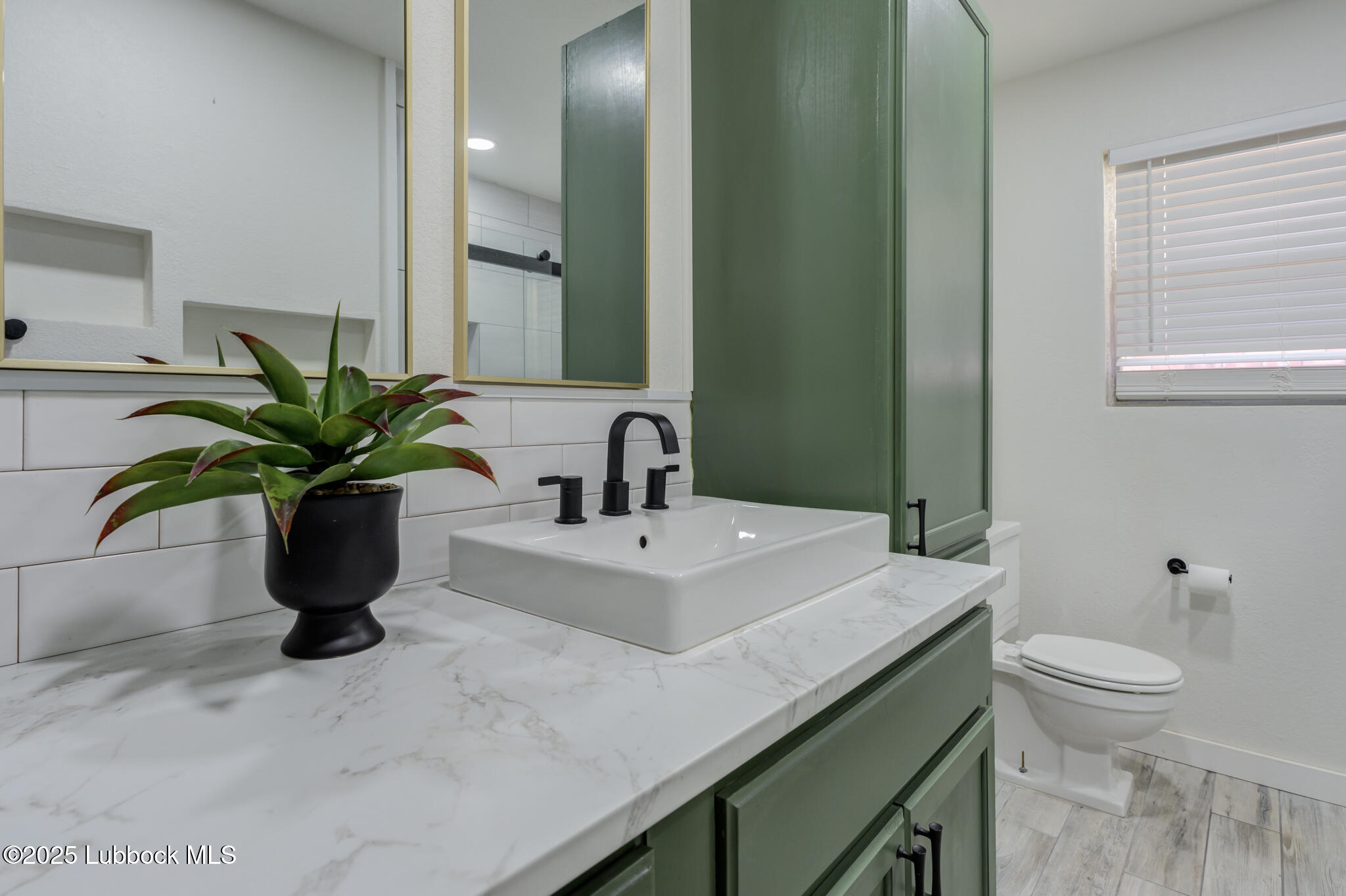1205 Garland Plainview, TX 79072 - Photo 33 of 50 a bathroom with a sink a toilet and a mirror