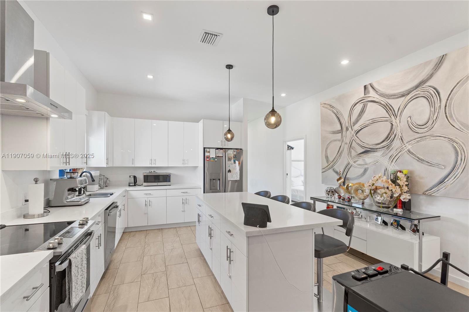 10925 Southwest 218th Terrace Miami, FL 33170 - Photo 17 of 32 a large kitchen with stainless steel appliances a stove a sink dishwasher a refrigerator and white cabinets with wooden floor