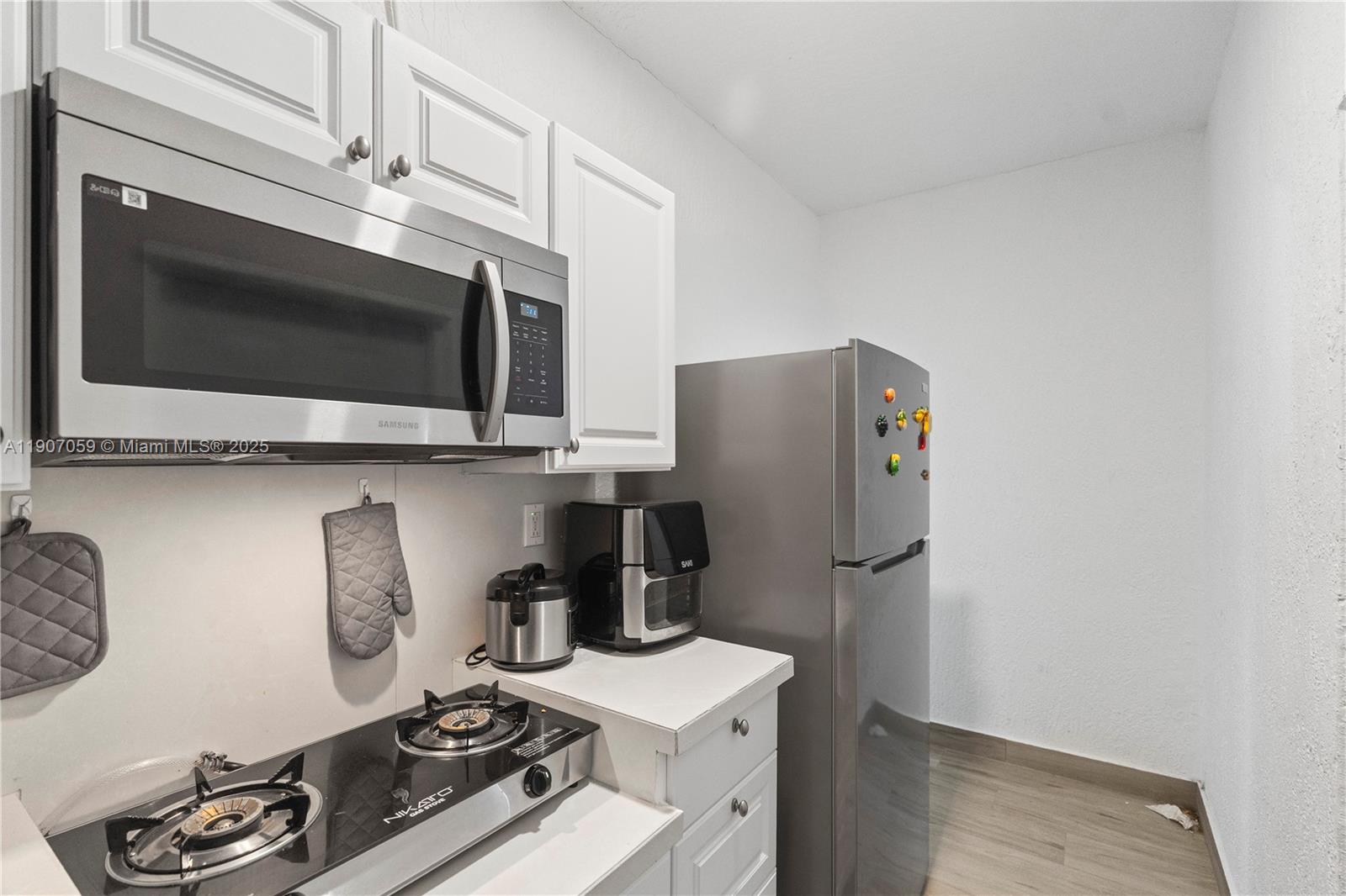 10925 Southwest 218th Terrace Miami, FL 33170 - Photo 28 of 32 a kitchen with stainless steel appliances a stove a microwave and wood floor