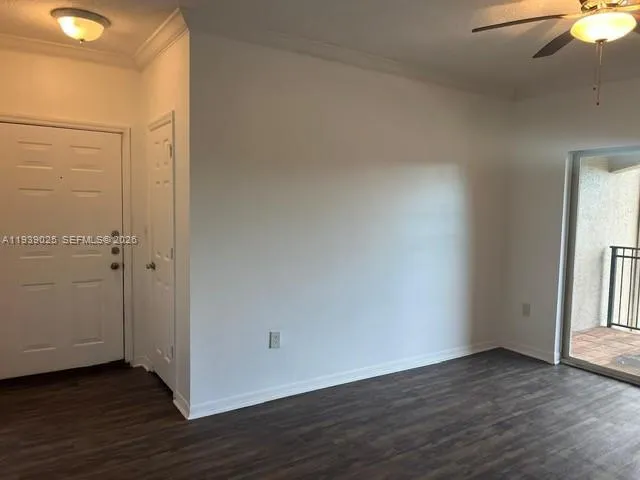 a view of an empty room with wooden floor and closet