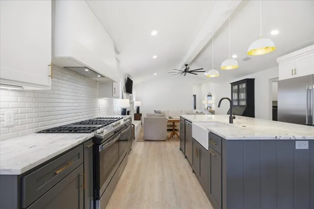 a kitchen with stainless steel appliances granite countertop a refrigerator and a sink