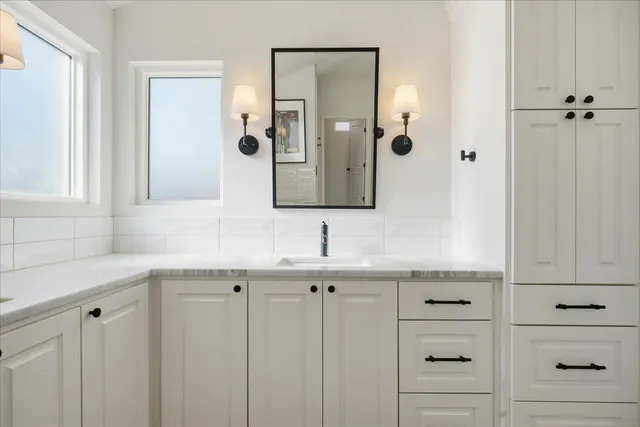 a kitchen with granite countertop white cabinets and a stove