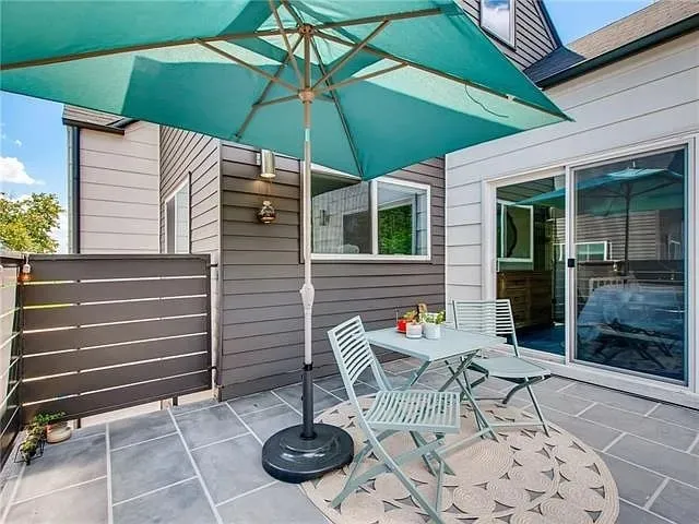 a patio with a table and chairs under an umbrella