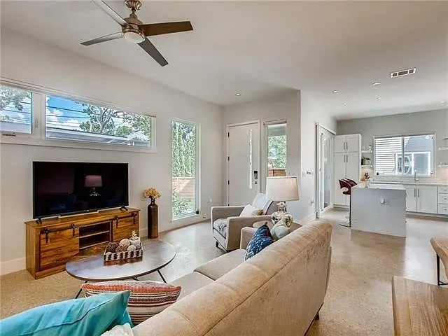 a living room with furniture a flat screen tv and a fireplace