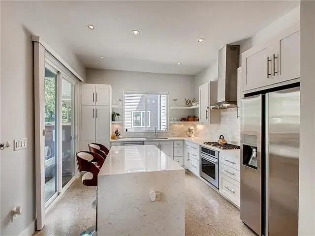 a kitchen with refrigerator a stove and cabinets