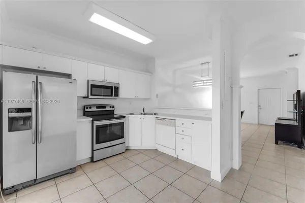 a kitchen with white cabinets and stainless steel appliances