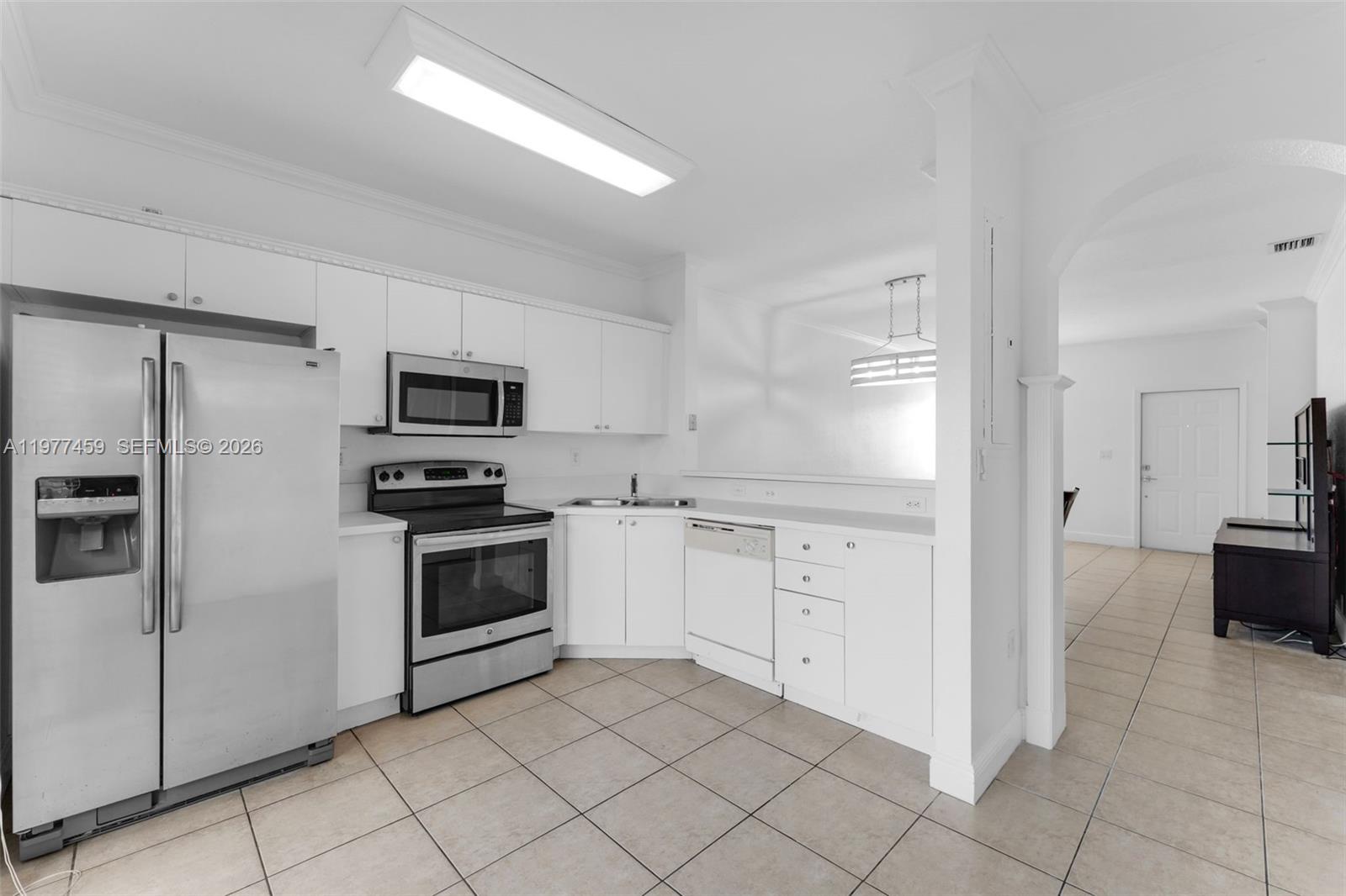 17040 Southwest 137th Place Miami, FL 33177 - Photo 6 of 29 a kitchen with white cabinets and stainless steel appliances