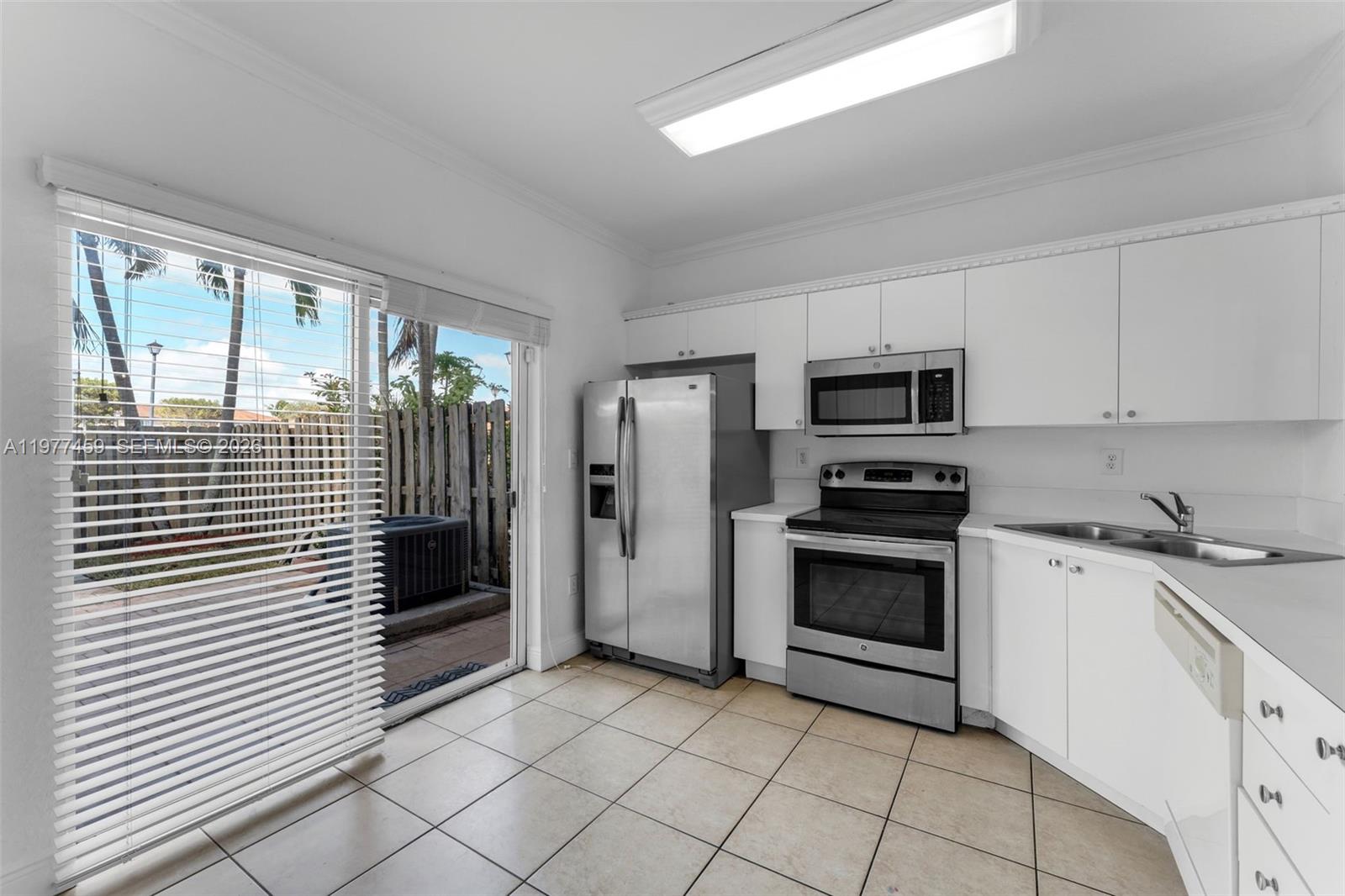 17040 Southwest 137th Place Miami, FL 33177 - Photo 8 of 29 a kitchen with a stove a sink and a microwave
