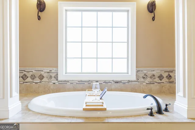 a bathroom with a bathtub and next to a window