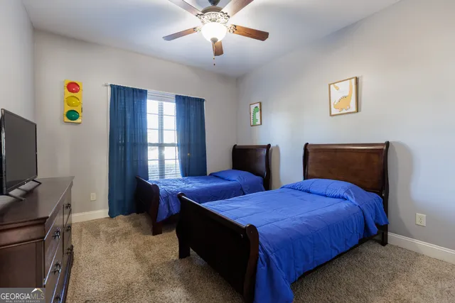 a bathroom with a granite countertop double vanity sink toilet mirror and shower