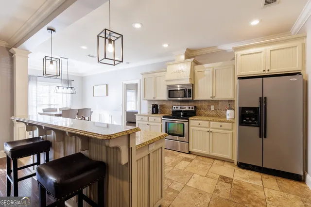 a kitchen with cabinets and chairs