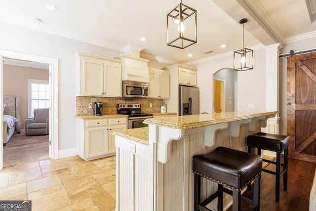 a large kitchen with stainless steel appliances kitchen island granite countertop a sink and cabinets