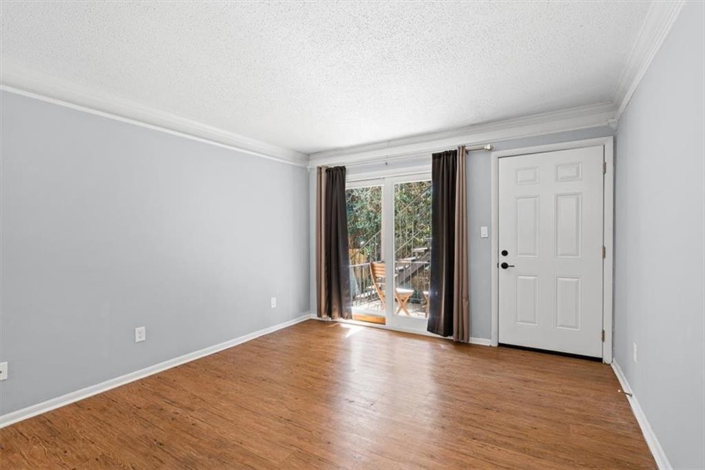1225 Church Street, Unit J Decatur, GA 30030 - Photo 4 of 27 a view of an empty room with wooden floor and a window