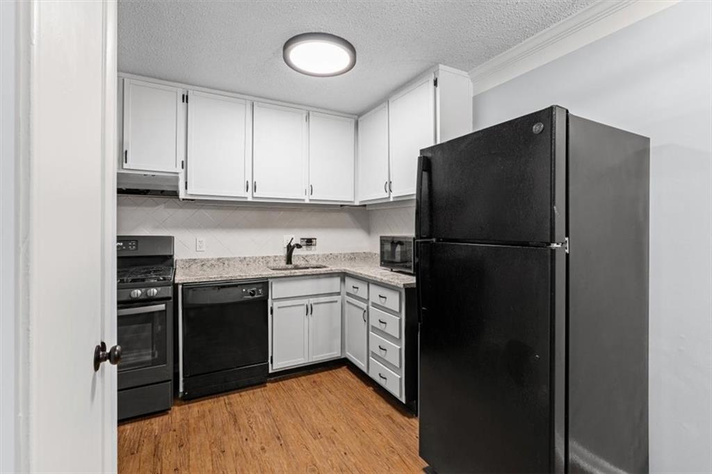 1225 Church Street, Unit J Decatur, GA 30030 - Photo 6 of 27 a kitchen with a refrigerator and white cabinets