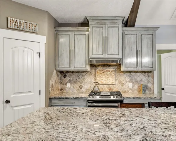 a kitchen with granite countertop a sink and a stove