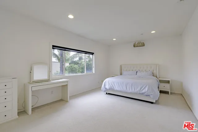 a bedroom with a bed and a large window