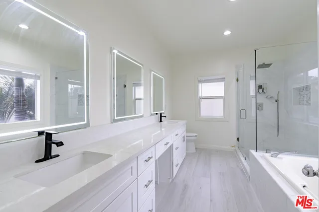 a bathroom with a bathtub a sink a mirror and a shower