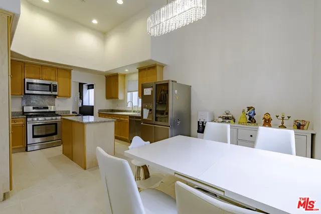 a kitchen with stainless steel appliances granite countertop a sink refrigerator and microwave