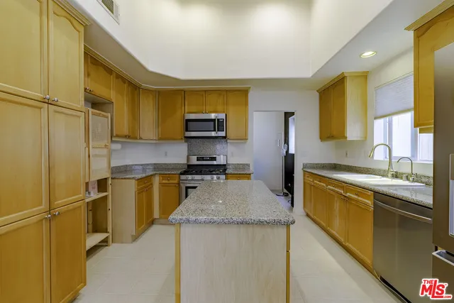 a kitchen with stainless steel appliances granite countertop a refrigerator a stove top oven a sink and dishwasher