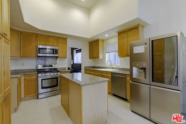 a spacious bathroom with a granite countertop sink a mirror and a bathtub