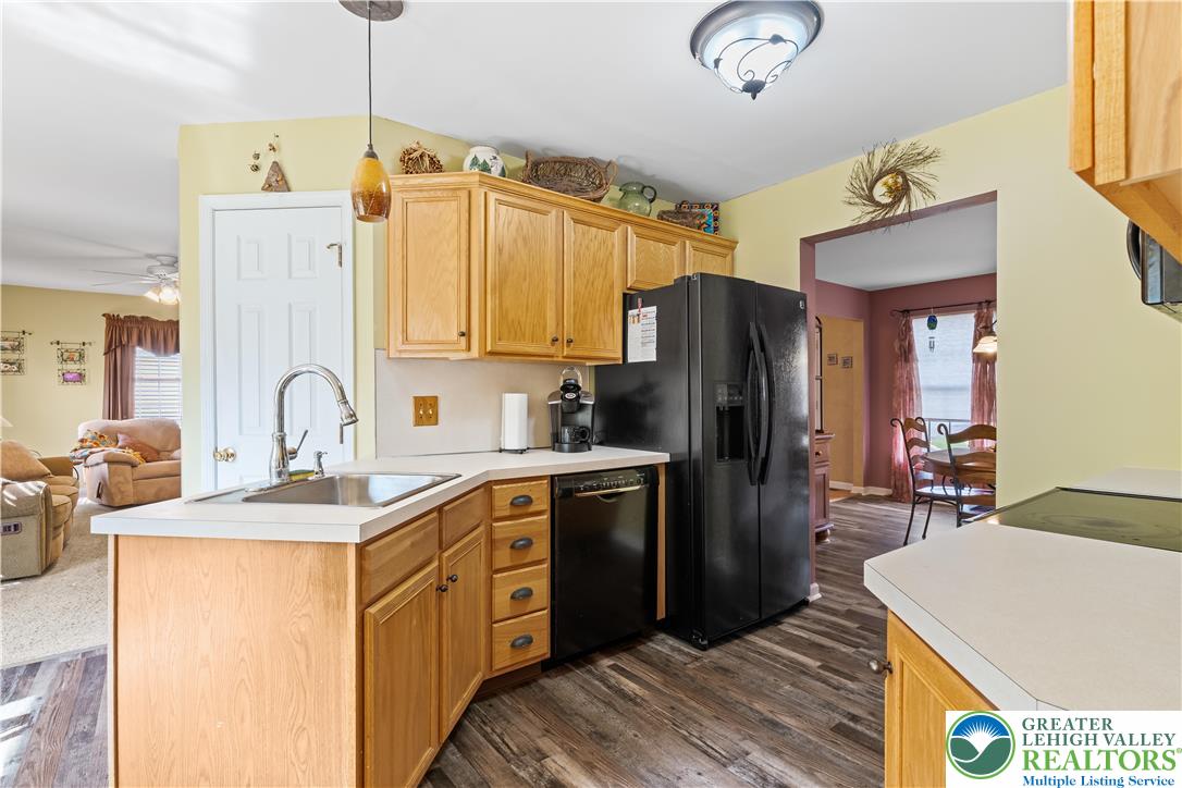 2652 Thistle Road Lower Macungie Township, PA 18062 - Photo 20 of 66 a kitchen with stainless steel appliances granite countertop a refrigerator a sink dishwasher a stove and a dining table with wooden floor