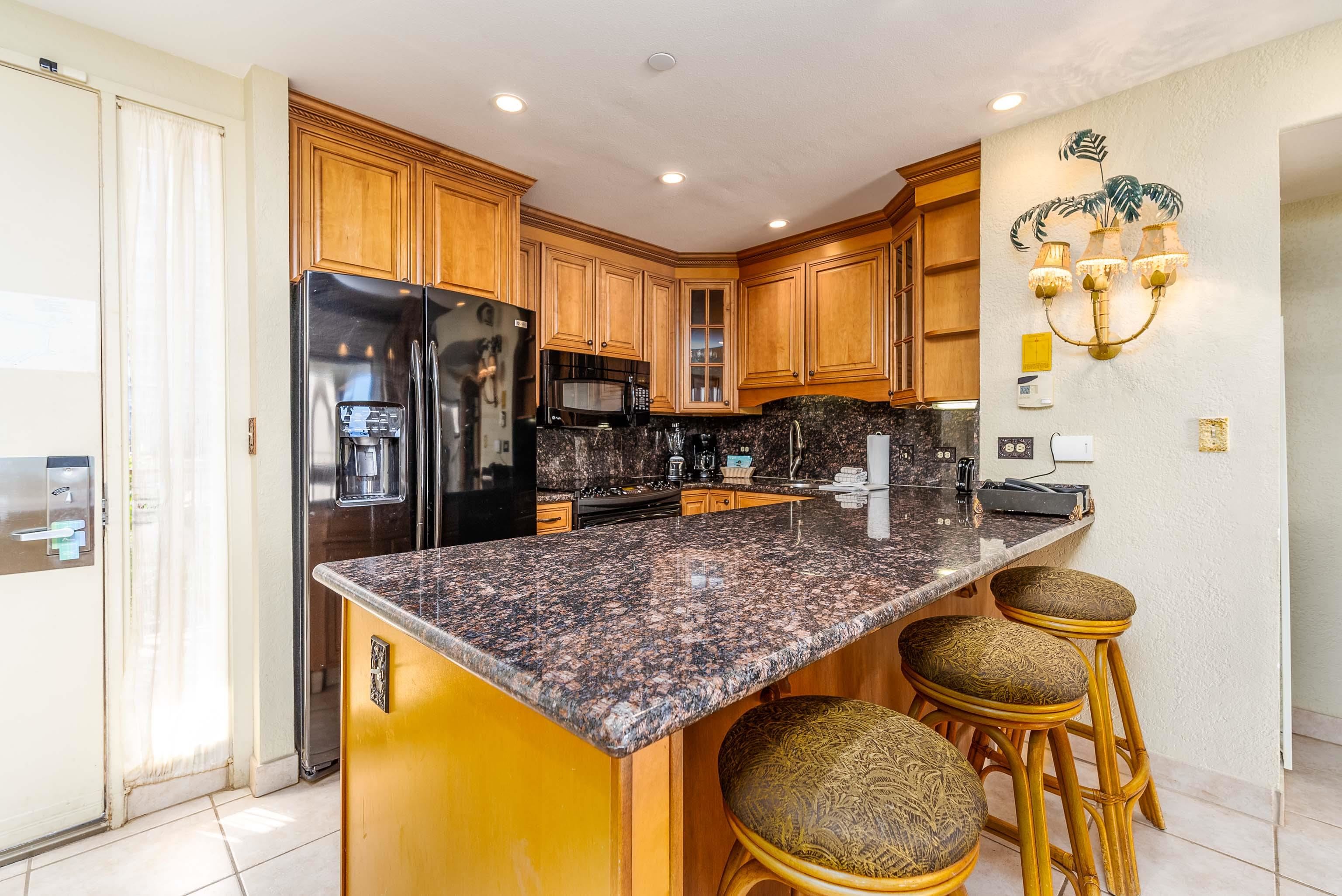 3445 Lower Honoapiilani Road, Unit 456 Lahaina, HI 96761 - Photo 8 of 32 a kitchen with stainless steel appliances granite countertop a sink and a refrigerator