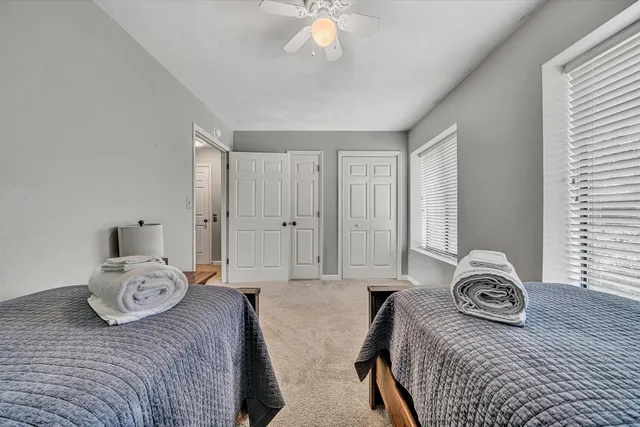 a bedroom with two bed and a chandelier