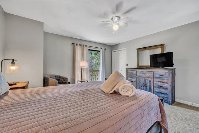 a bedroom with a bed and a flat tv screen on dresser