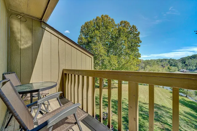 a view of a balcony with wooden floor and outdoor seating