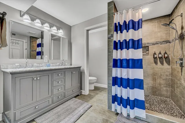 a bathroom with a sink a toilet and shower