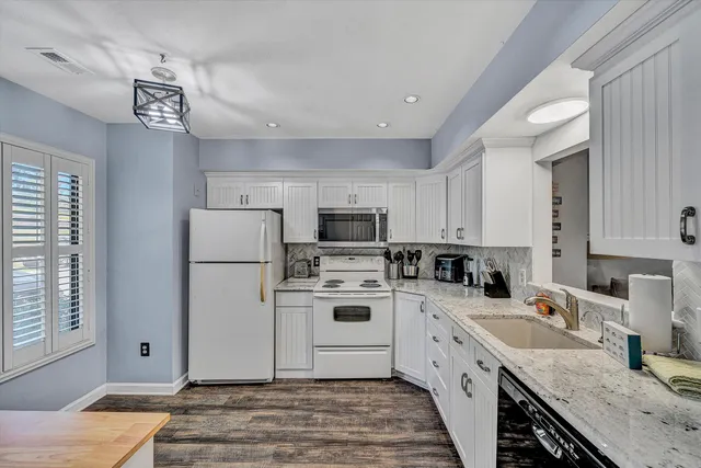 a kitchen with a sink dishwasher a stove and a refrigerator with wooden floor